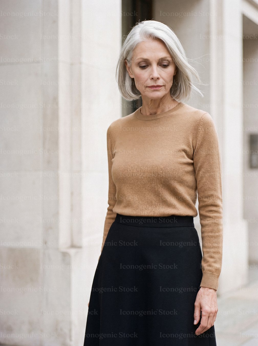 Elegant senior woman with grey hair standing outdoors in stylish urban city setting