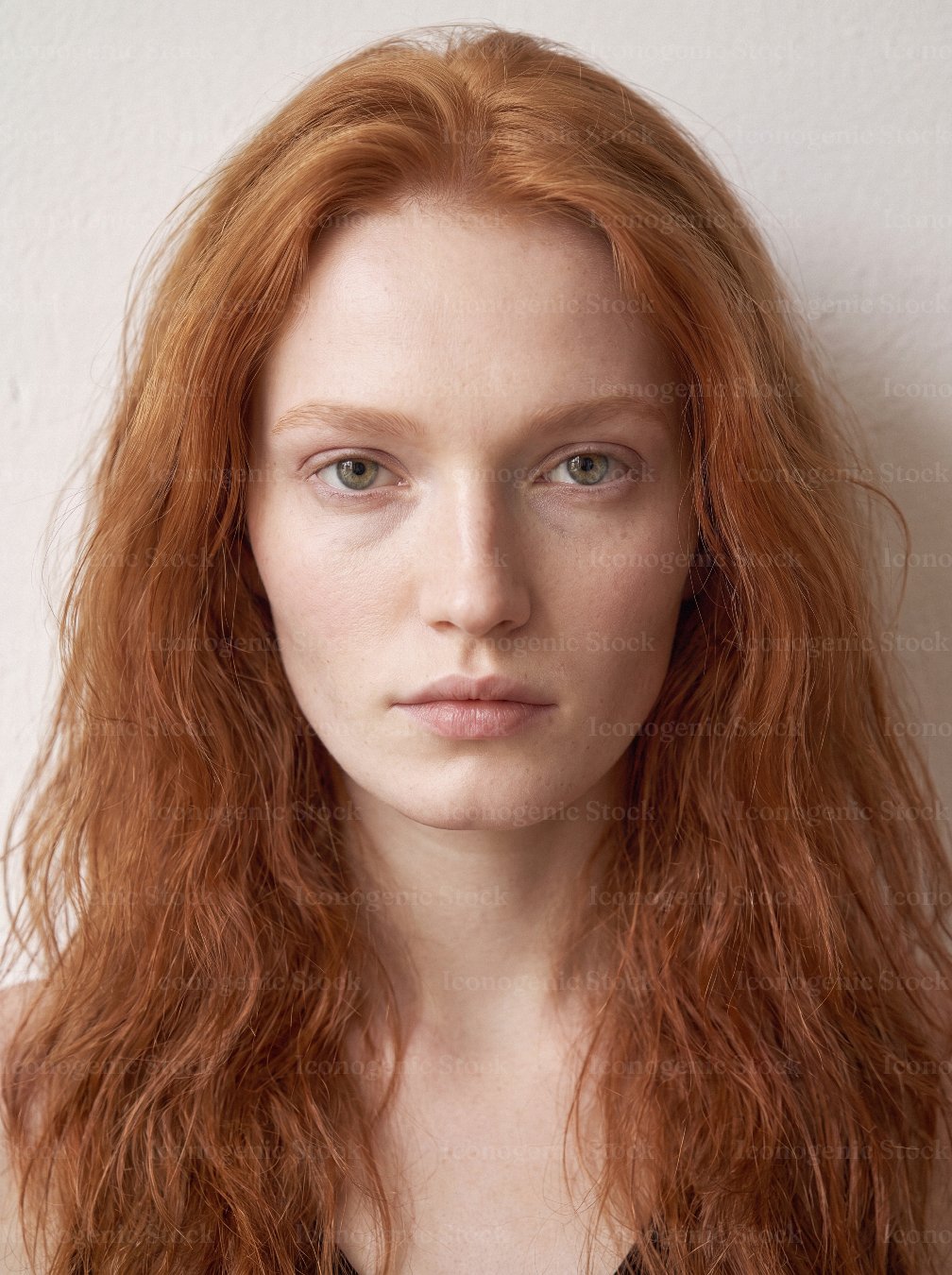 Natural portrait of young redhead woman with long wavy hair and freckles, no makeup