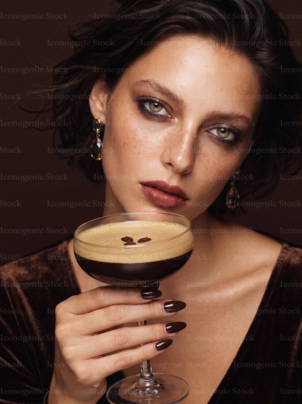 Elegant woman with green eyes holding an espresso martini cocktail glass